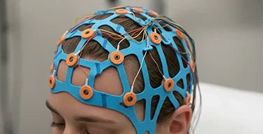 Patient wearing a blue disposable EEG cap